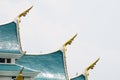 Small finials jutting out of the side Ã¢â¬â corners of the blue gable roof, representing the heads of naga.